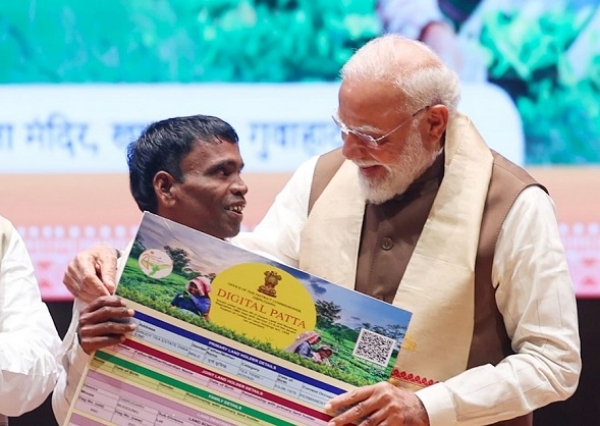 گوہاٹی میں جمعہ کو منعقدہ پروگرام میں چائے قبائلی برادری کے ایک شخص کو زمین کا پٹہ فراہم کرتے ہوئے وزیر اعظم نریندر مودی